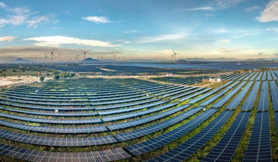 Planta solar fotovoltaica con aerogeneradores al amanecer